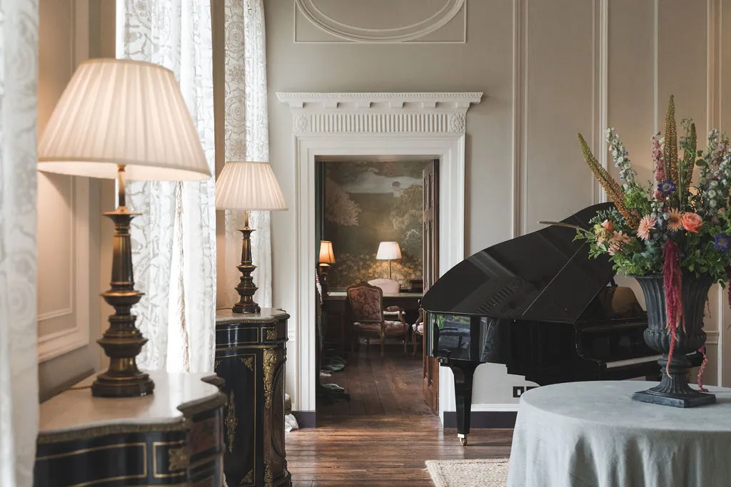 A doorway between reception rooms, flanked by lamps