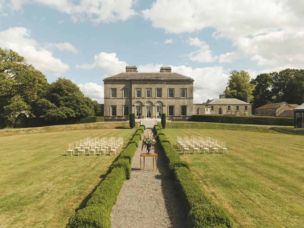The house at the end of the lawn, ceremony chairs in the foreground