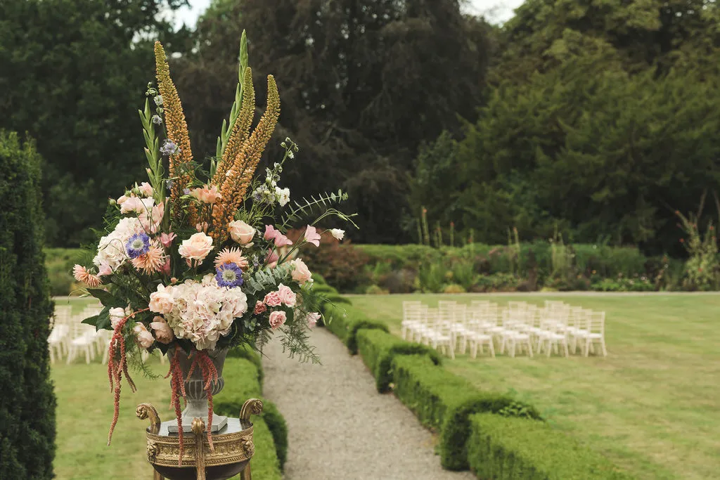 Arrangements of garden flowers marking the ceremony aisle