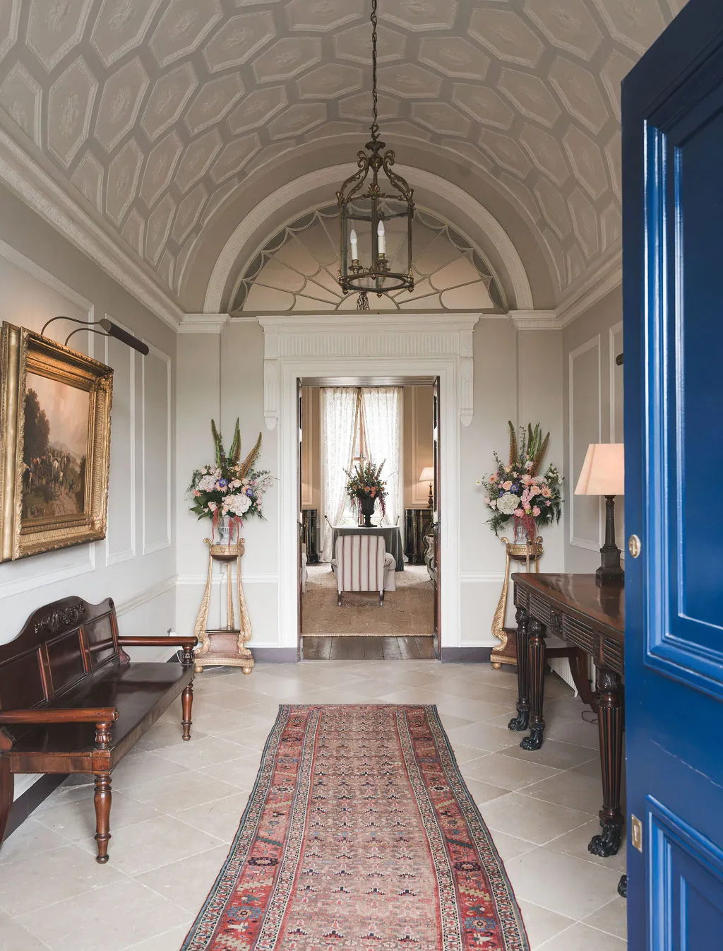 The entrance hall of the Manor House, seen through the open blue front door
