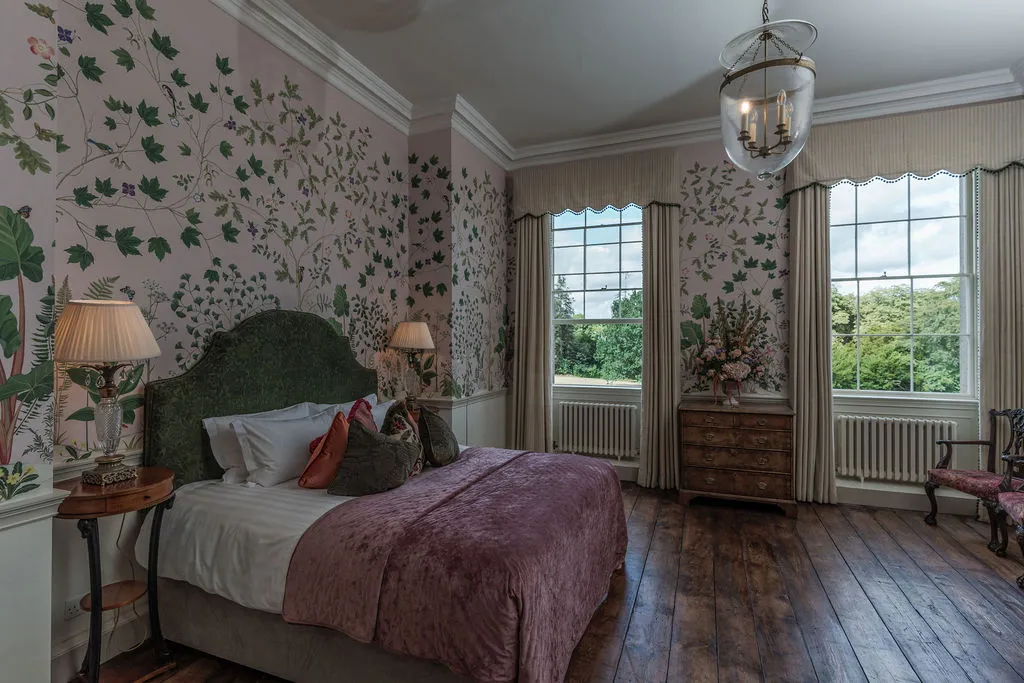 A bedroom papered with trailing vines