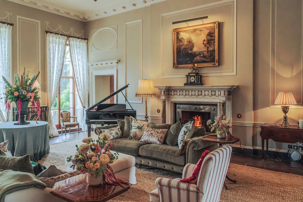 The piano room, with a grand piano, deep sofas and an open fire